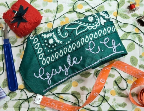 a green bandana embroidered with a name 