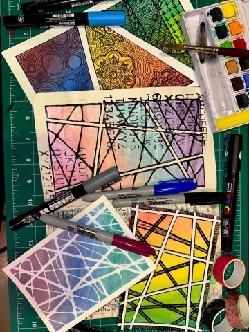 picture of watercolor paintings with doodles and mandalas drawn on them