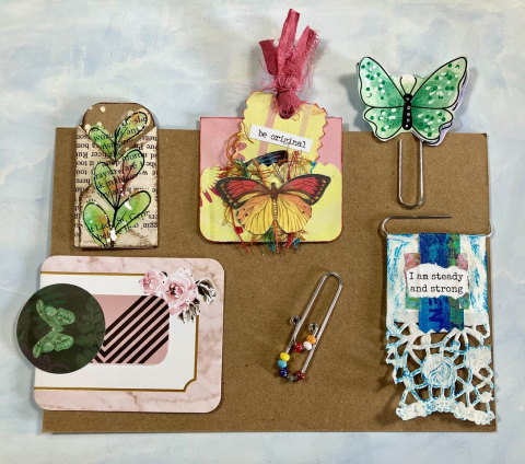 an assortment of paperclips with added butterflies, beads, and other images to make them extra fancy