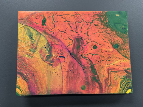 Canvas painted with reds, oranges and swirled colors
