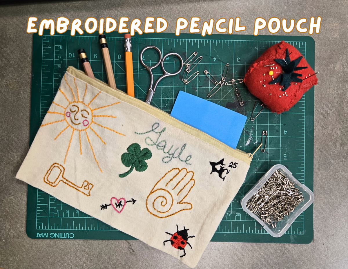 a pencil pouch with embroidered doodles on the front.