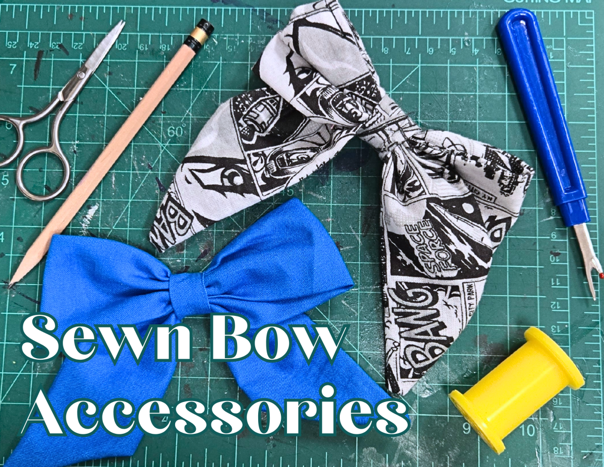 Two fabric bows, one blue and one newsprint patterned.