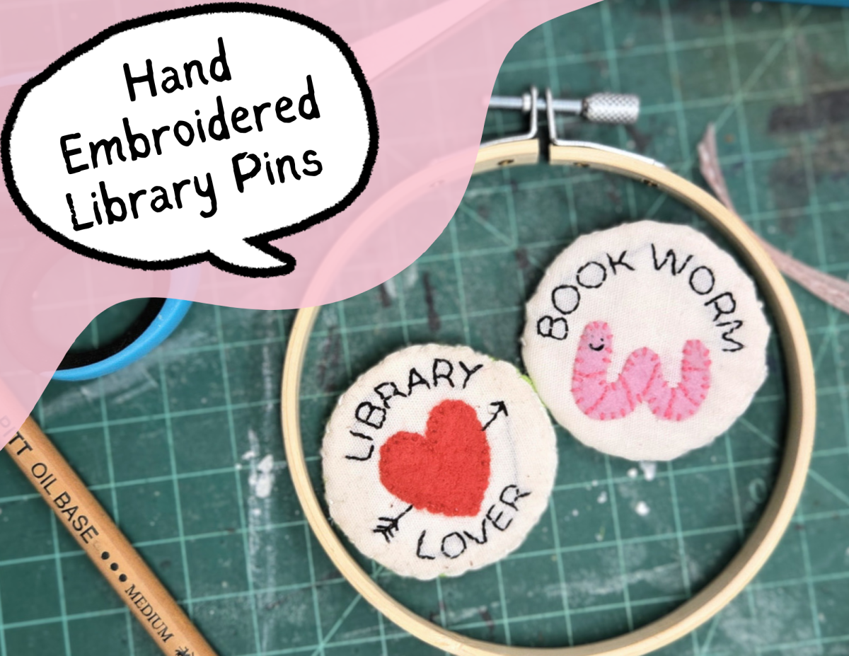 two small embroidered pins one says, "Library Lover" and the other says "Book Worm".