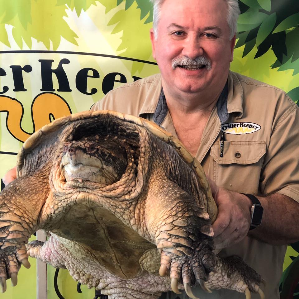 Randy Miller, the Critter Keeper, holding a snapping turtle.